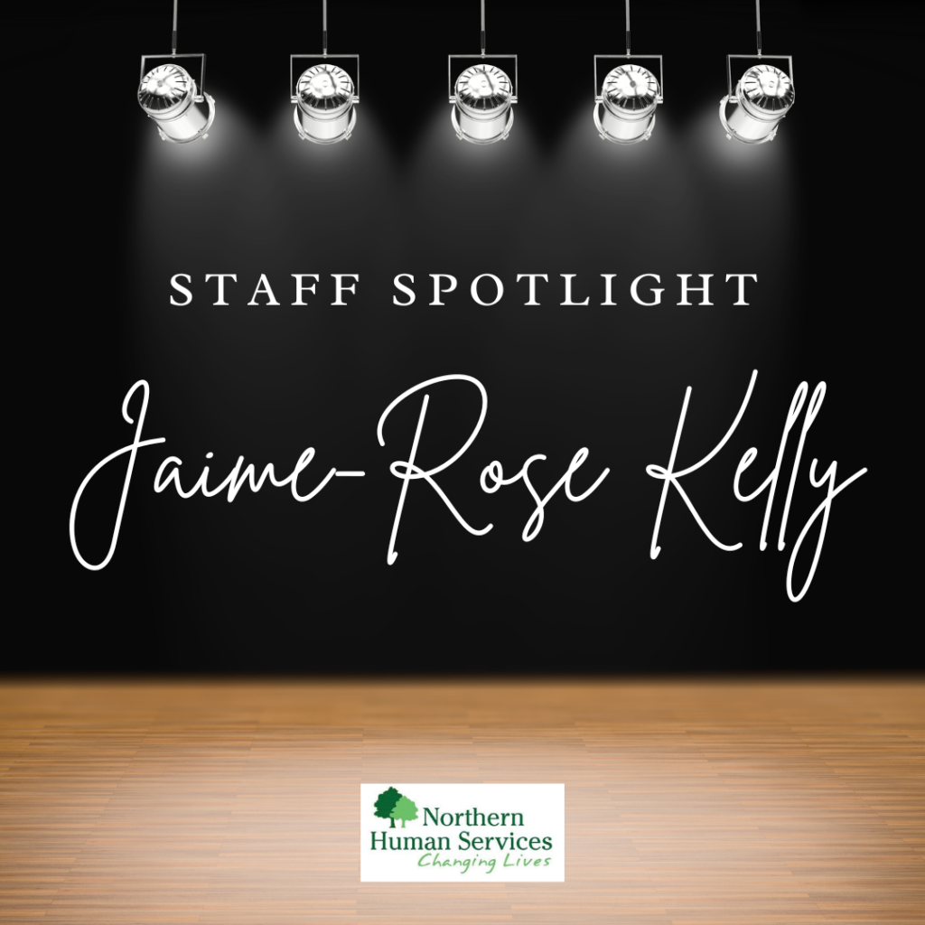 A stage with black background and five spotlights shining on the text Staff Spotlight Jaime-Rose Kelly